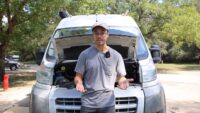Chris explaining car overheating with no leaks beside his van with the hood open
